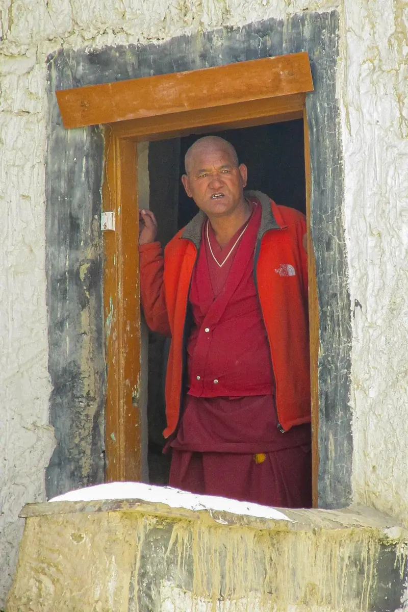A monk standing in a narrow wooden doorway